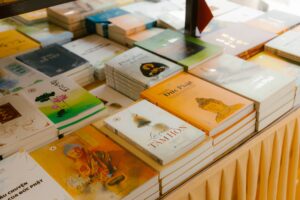 A diverse collection of books neatly arranged on a table indoors.